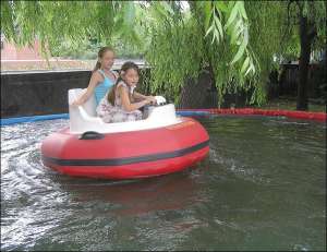 12-річна Аня та 6-річна Дарина катаються на човні у штучно зробленому басейні 