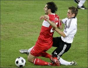 Защитник сборной Германии Филипп Лам (справа) противостоит правому линейному Турции Хамиту Алтинтопу. Лам забил во встрече решающий гол, который назвал важнейшим в карьере. Телетрансляция матча на Европу прерывалась из-за грозы в Австрии. Непогода стала п