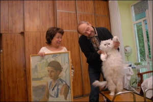 Наталя Паторжинська показує свій портрет дитячих років. Її чоловік Василь Манолов грається з котом  Мартіном