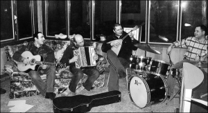 Віктор Нос із Полтави (третій зліва) зі своїми друзями грає на балалайці в кімнаті найманого будинку в місті Брукс у Канаді. Там чоловік працював на м’ясокомбінаті. Заробив на ремонт свого будинку в Рибцях під Полтавою