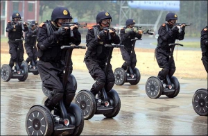 Китайские полицейские демонстрируют умение управлять самокатами-сигвеями и мини-автоматами во время публичных маневров в городе Цзинань