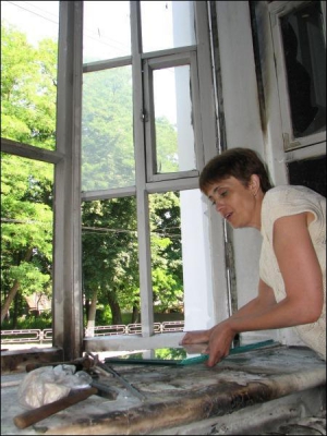 Завхоз юношеской библиотеки Чернигова Ирина Андрийко подает стекло, которое рабочие должны вставить вместо побитых окон. Пожар возник после полуночи. Книгохранилище подожгли