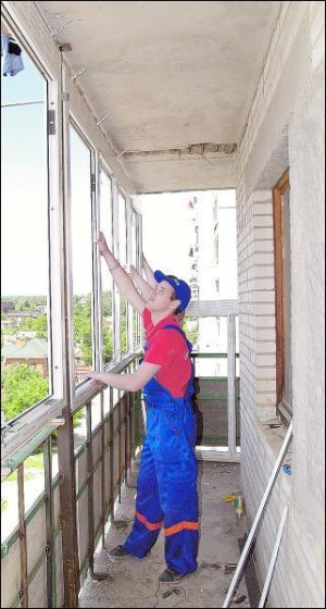 Працівники компанії ”Корса” встановлюють металопластикові вікна на балконі сьомого поверху