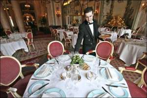 Официант накрывает столы для ленча в пустом лондонском ресторане ”Ритц”. С начала года в стране резко подорожали продукты, что негативно отразилось на ресторанном бизнесе
