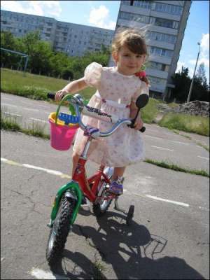 Маша Диденко катается на велосипеде на площадке возле школы № 32 в Черкассах. Снимок сделали 11 июля этого года. Девочка говорит, что от смерти ее спасла Матерь Божья