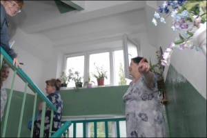 Валентина Кравчук (справа) разом із сусідками Наталею та Олесею Вальдман (зліва) на четвертому поверсі відремонтованого під’їзду. Перед тим як фотографуватись, вони переодяглись. За квітами на підвіконнях доглядають мешканці відповідного поверху