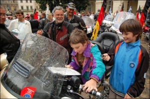 11-річні львів’яни Максим та Ростик (у центрі) розглядають мотоцикл 55-річного німця Гоуста Поедага на площі Ринок у Львові