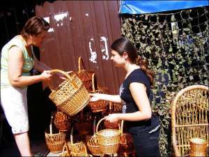 Продавець Ольга Сторчак (ліворуч) на Центральному ринку  пропонує плетеного  кошика Наталії Корнилич