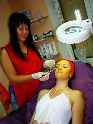 Косметолог салону ”Імперія краси” в Полтаві Вероніка Сліпко наносить маску з фруктів та овочів на обличчя клієнтці. Вона живить та відбілює шкіру після засмаги 