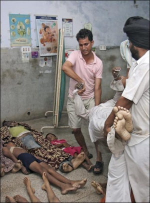 Рятувальники виносять тіла задавлених прочан із храму Наїна Деві індійського міста Хімачал Прадеш до лікарень, а звідти до моргів