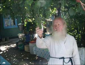 Архімандрит Ілія на подвір’ї будинку матері в містечку Ямпіль Вінницької області, де народився і виріс. Отець Ілія каже, що такий виноград є тільки вдома. Він посадив його у 1964-му році, коли працював агрономом