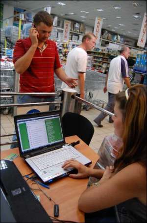 Во львовском супермаркете ”Рукавичка” Александр Тимощук разговаривает с клиентом по телефону. Его сестра 21-летняя Наталья принимает заказ через Интернет