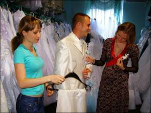 Олександр Попович і Аліна Ситник (праворуч) за місяць до одруження підбирають костюм у весільному салоні ”Пан+Пані” у Полтаві. Їм допомагає продавець-консультант Тетяна Філатова. Купили білий костюм за 650 гривень