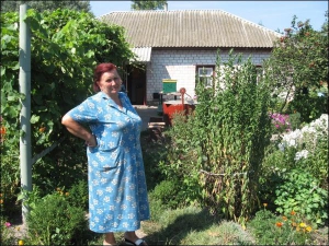 Киянка Євдокія Кривоборода стоїть на подвір’ї своєї садиби в селі Євминка Козелецького району на Чернігівщині. Будинок їй залишився від свекрів. У столичній квартирі жінки живе племінниця, іноді ночує син