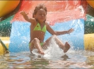Девочка ныряет в воду с горки. Детский аттракцион стоит 5 гривен