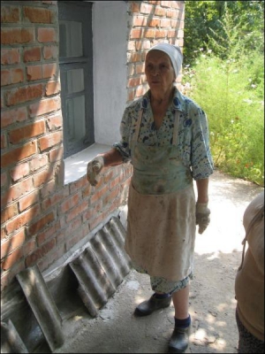 Марія Микитенко показує укріплений фундамент свого помешкання. Цього літа його заглибили на 70 сантиметрів і залили цементним розчином зі щебнем