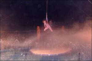 17-летняя акробатка Виктория Кныш выполняет номер - падение на ремнях. Выступление сопровождается дымовым эффектом и иллюминацией
