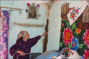 Жительница села Манява Евдокия Монастырецкая залепляет глиной стены, потрескавшиеся после наводнения на Ивано-Франковщине