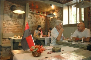 На столах нового Ивано-Франковского кафе ”Бункер” на улице Вагилевича, 6, стоят букеты калины и красно-черные флаги УПА