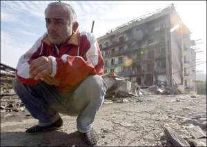 Житель грузинского города Гори у своего дома, разбомбленного 11 августа 2008 года