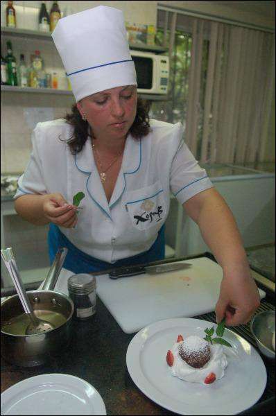 Шеф-повар ресторана ”Хорив” Людмила Руденко украшает мороженое во фритюре сахарной пудрой, клубникой и листками мяты. Есть посетители, которые приходят в заведение только ради этого блюда