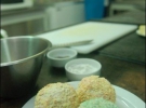 Кульки морозива у бісквітних крихтах і клярі за третім разом панірують у кольоровій кокосовій стружці