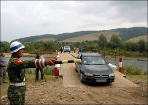 Первые автомобили следуют через временный мост в село Крушельница Сколовского района Львовщины