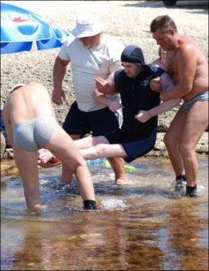 На мисі Тарханкут у Криму інструктори вдягли 32-річного вінничанина Олександра Марченка в гідрокостюм і несуть до води