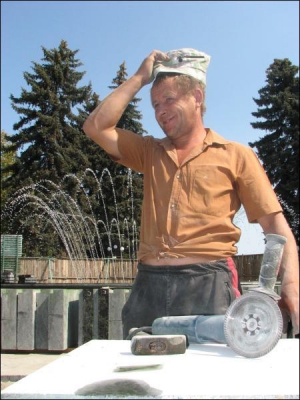 Рабочий Александр Федорчук шлифует камень лабрадорит возле светомузыкального фонтана в сквере им. Попудренко в Чернигове