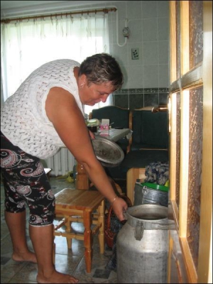 Гавриленко показывает бидоны с водой на кухне своей квартиры в поселке Репки-1 на Черниговщине