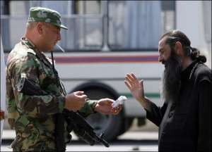 Российский офицер предлагает сигарету грузинскому священнику. Тот отказывается. г. Гори, Грузия, 18 августа 2008 года