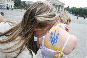 Участники акции ”Раскрасим сердца в желто-синие цвета” разрисовывают друг друга государственными символами на Театральной площади в Тернополе 