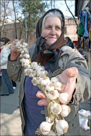 На рынках Закарпатья женщины продают косы из чеснока, выращенного на собственном огороде. Урожай высаженного в конце сентября озимого чеснока собирают в середине июля