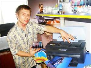 Продавец-консультант магазина фирмы ”Цифрадель” в Полтаве Ярослав Боровинский показывает резервуары для непрерывной подачи чернил к принтеру ”Кенон”. Такая система может работать без картриджа