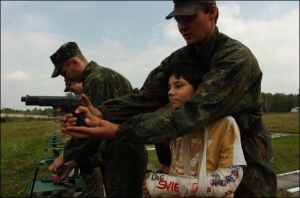 Военнослужащие внутренних войск помогают детям стрелять из пистолета на стрельбище учебного центра ВВ МВД Украины. Буча, Киевская область, 29 августа 2008 года