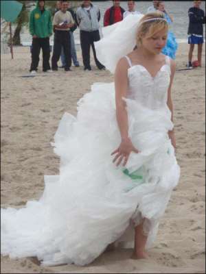 Студентка Кременчуцького державного політехнічного університету Аліса Стрюк демонструє весільну сукню з поліетилену на Центральному пляжі Кременчука під час обласного чемпіонату з пляжного футболу серед молоді