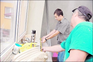 Степан Грицюк (ліворуч) та Богдан Мирський вимірюють довжину підвіконня у новобудові на вулиці Джорджа Вашингтона у Львові