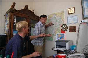 Юрій Маркевич (ліворуч) та Тарас Кудін (біля карти) обговорюють туристичні маршрути Карпатами в офісі турфірми