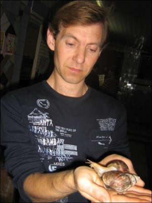 Старший лаборант навчальної ферми Полтавської аграрної академії Руслан Шевченко показує равликів-ахатинів. Щоб вони виставили ріжки, поклав їх на теплу долоню
