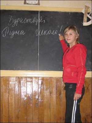 Восьмиклассница Каменской школы №3 Анастасия Шкреба пишет на доске приветствие для одноклассников. Идти из своей школы девочка не хочет