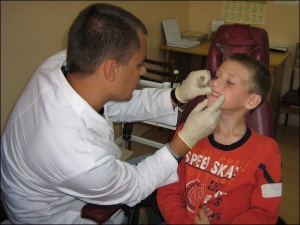Лікар-ортодонт Вінницької дитячої стоматологічної лікарні Тимур Сорока оглядає 9-річного Андрія Гаращука. Хлопчик носить пластинку для вирівнювання зубів п’ятий місяць. Каже, що вона йому не заважає