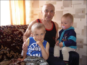 Анатолий Присяжнюк с внуками Дмитрием (слева) и Станиславом в своем доме в поселке Владимирец на Ривненщине