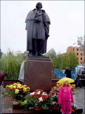 Біля щойно відкритого пам’ятника письменнику Миколі Гоголю в Миргороді через дощ дівчинка фотографується під парасолею