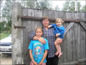 Олена Клюсовець із дітьми Валерією (тримає на руках) та Володимиром біля своєї хати в селі Нові Боровичі Щорського району на Чернігівщині. У жінки є ще четверо старших дітей