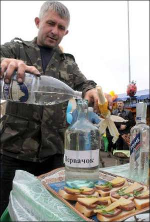 Продавец переливает самогон в бутылку с надписью ”Первак” на Слободской ярмарке. Харьков, 21 сентября 2008 года