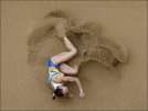 На фото, виставлених у столичному Палаці спорту: Українська легкоатлетка Людмила Блонська приземляється в ямі з піском після стрибка 19 серпня 2008 року