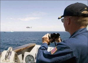 Американский военный моряк наблюдает за судном ”Фаина”, захваченным пиратами 30 сентября 2008 года