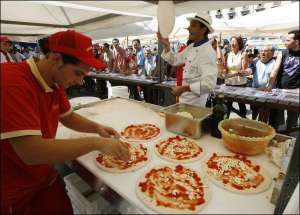 30 поваров города Неаполь приготовили самую дешевую в мире пиццу ”Маргарита”. На тесто положили моцареллу, помидоры и базилик