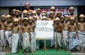 У День миру в Індії серед дітей проводили конкурс на звання кращого двійника Махатми Ганді. Плакат у центрі закликає зупинити тероризм