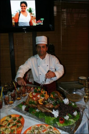 Повар Сиро из ресторана-паба ”Куба” разрезает и поливает соусом фирменную ”Индейку с розмором”. Внутри птицы рис и фасоль со специями